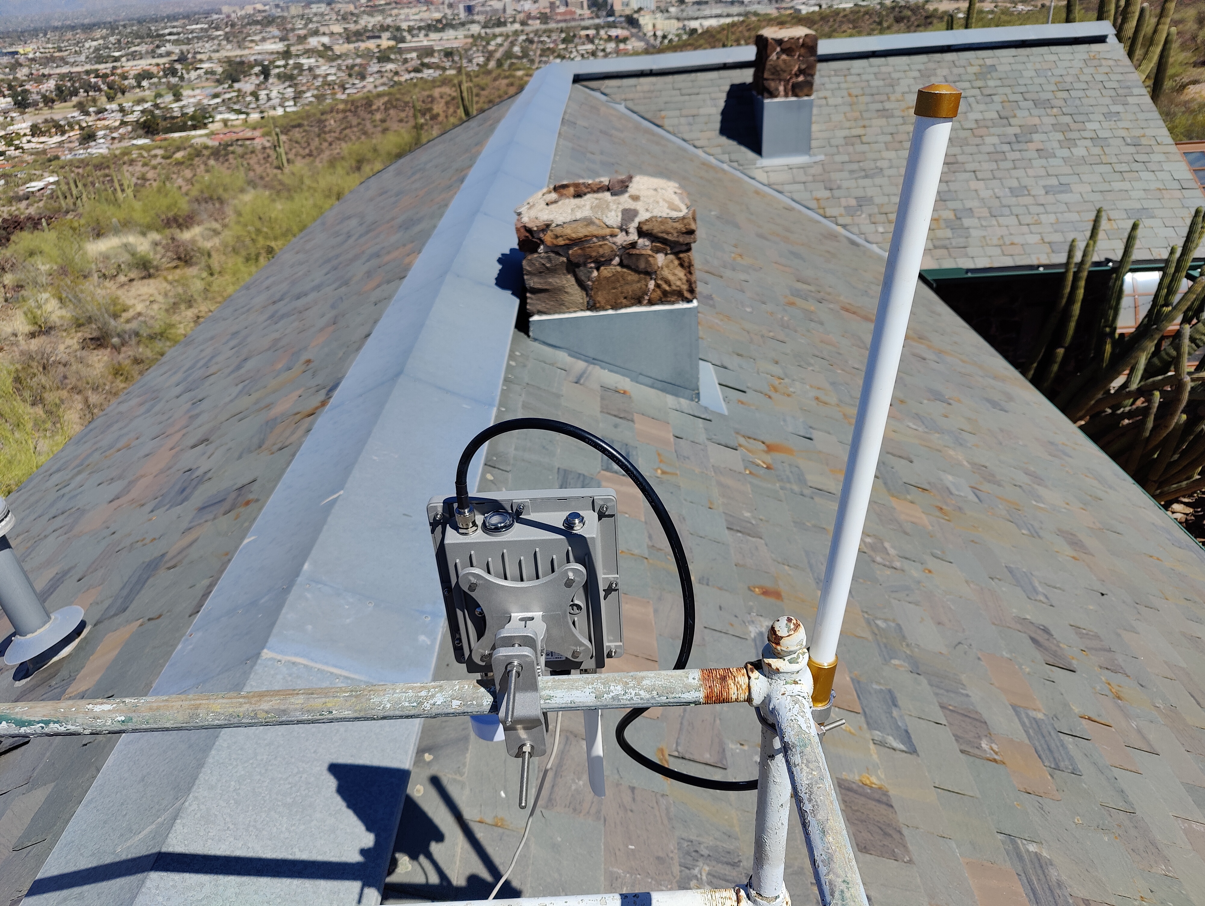 A LoRaWAN gateway and antenna installed at the top of the main laboratory building on Tumamoc Hill.